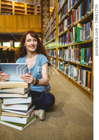 Mature student in library using tablet Mature student in library using tablet 19661739