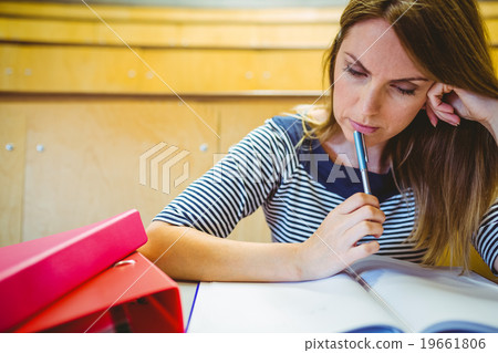 Mature student taking notes in lecture hall 19661806