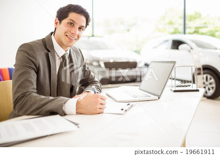 Smiling salesman behind his desk Smiling salesman behind his desk 19661911