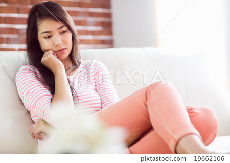 Upset asian woman on couch  19662106