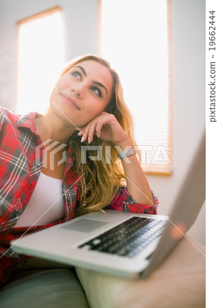 Pretty blonde using laptop on couch 19662444
