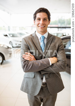 Smiling businessman standing with arms crossed Smiling businessman standing with arms crossed 19662509