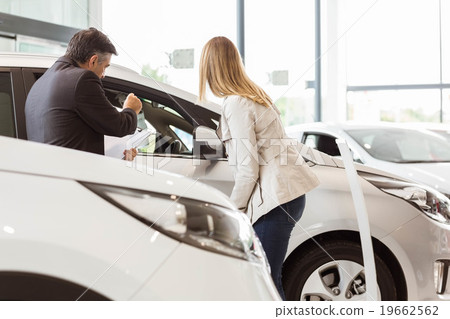Salesman showing a car to a client Salesman showing a car to a client 19662562
