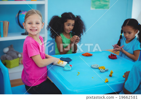 Smiling girls playing with modelling clay Smiling girls playing with modelling clay 19662581
