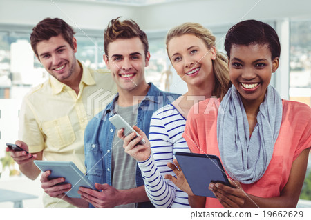 Smiling creative team standing in a line using technology Smiling creative team standing in a line using technology 19662629