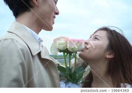 A couple giving bouquets A couple giving bouquets 19664369