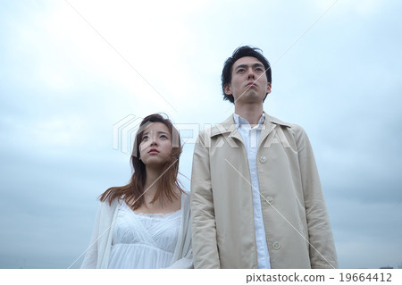 A couple standing outdoors 19664412