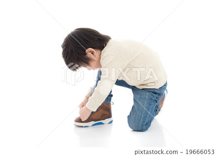 little boy tying his shoes isolated in white 19666053