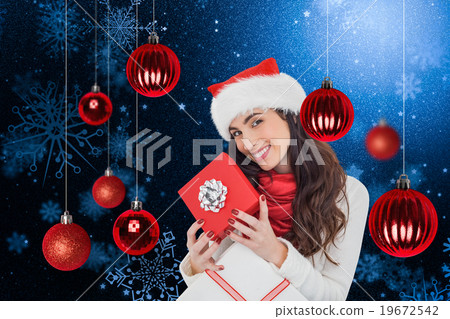 Composite image of smiling brunette holding christmas gifts Composite image of smiling brunette holding christmas gifts 19672542