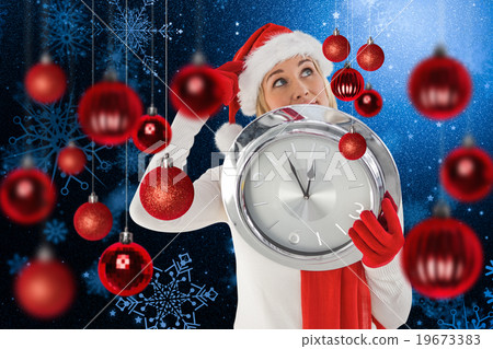 Composite image of festive blonde holding a clock 19673383
