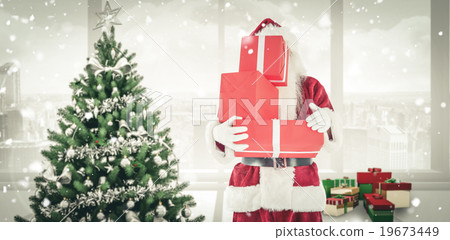 Composite image of santa covers his face with presents 19673449