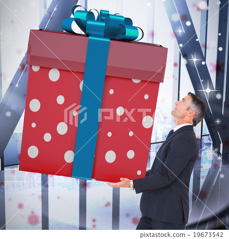 Composite image of stylish man with giant gift Composite image of stylish man with giant gift 19673542