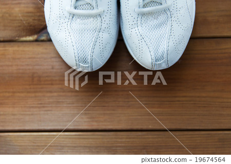 close up of sneakers on wooden floor 19674564
