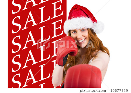 Composite image of festive redhead punching with boxing gloves Composite image of festive redhead punching with boxing gloves 19677529