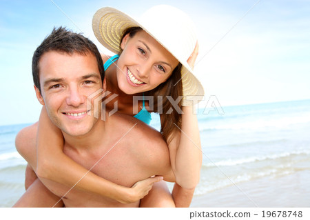 Free Photo  Man giving piggyback ride to woman on the beach