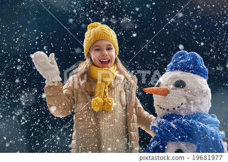girl plaing with a snowman 19681977
