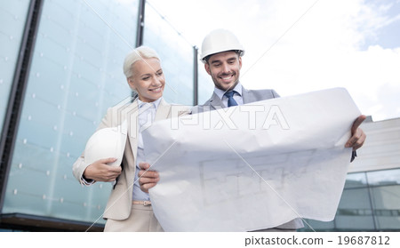 smiling businessmen with blueprint and helmets smiling businessmen with blueprint and helmets 19687812