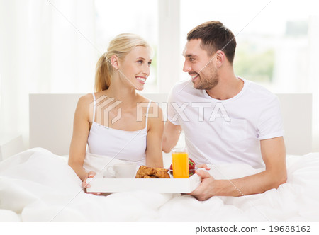 happy couple having breakfast in bed at home 19688162