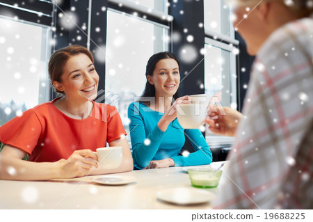 happy young women drinking tea or coffee at cafe happy young women drinking tea or coffee at cafe 19688225