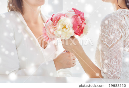 close up of happy lesbian couple with flowers close up of happy lesbian couple with flowers 19688230