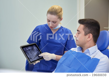 female dentist with tablet pc and male patient 19688830