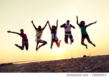 smiling friends dancing and jumping on beach 19688952
