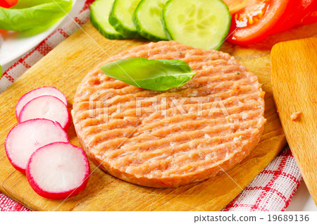 图库照片: raw minced meat patty and vegetables