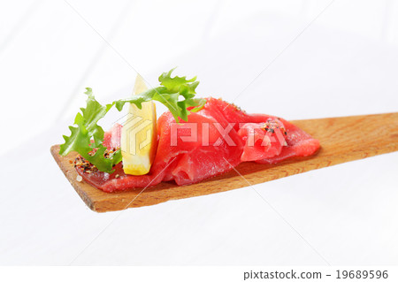 Slices of raw beef on spatula Slices of raw beef on spatula 19689596