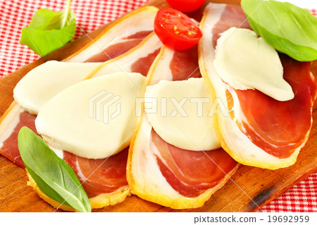 Sliced prosciutto and mozzarella with basil and tomatoes Sliced prosciutto and mozzarella with basil and tomatoes 19692959