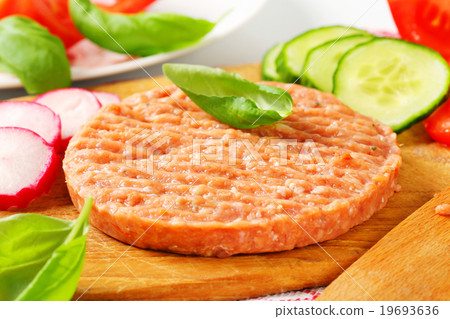 图库照片: raw minced meat patty and vegetables