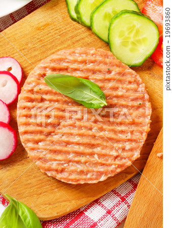 图库照片: raw minced meat patty and vegetables