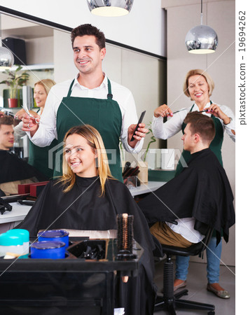 Young man cutting long hair of beautiful girl 19694262
