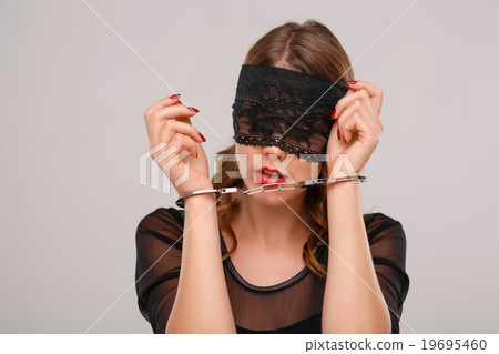 Sexual woman in eyeshade locked with handcuffs.  19695460
