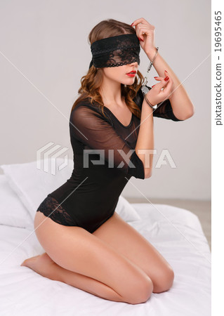 Sexual woman posing in eyeshade with handcuffs. 19695465