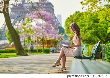Beautiful young woman in Paris, reading a book Beautiful young woman in Paris, reading a book 19697504