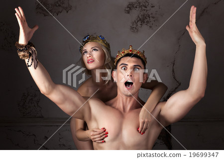 Guy with the crown on head sings his arms. 19699347