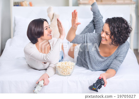 Sisters are high fiving in joy. Sisters are high fiving in joy. 19705027
