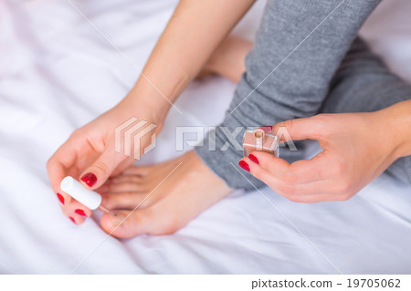 Woman is painting her toenails. Woman is painting her toenails. 19705062