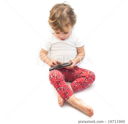 Little kid sitting and playing smartphone Little kid sitting and playing smartphone 19711900