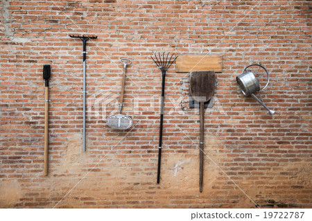 farmer instrument tool hanging on the brickwall 19722787