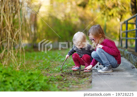 Two cute little sisters playing with a sticks 19728225