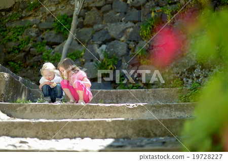 Two cute little sisters watching a bug 19728227