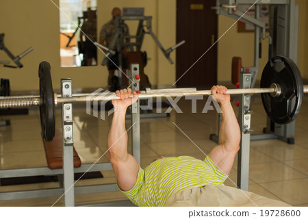 Bodybuilder lifts weights. 19728600