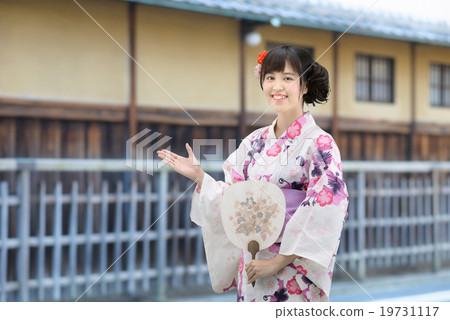 A young lady wearing a yukata standing in front of an old housewife 19731117