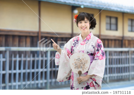 A young lady wearing a yukata standing in front of an old housewife 19731118