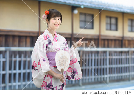 A young lady wearing a yukata standing in front of an old housewife 19731119