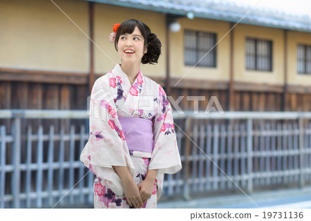 A young lady wearing a yukata standing in front of an old housewife 19731136