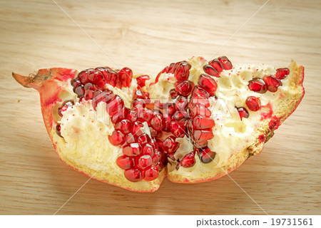 fresh juicy cut pomegranate on wooden background 19731561