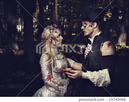 Dressed in wedding clothes romantic zombie man makes a proposal to his zombie girlfriend. Dressed in wedding clothes romantic zombie man makes a proposal to his zombie girlfriend. 19740066