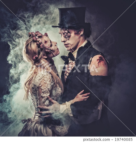 Dressed in wedding clothes romantic zombie couple walking on the abandoned cemetery. 19740085